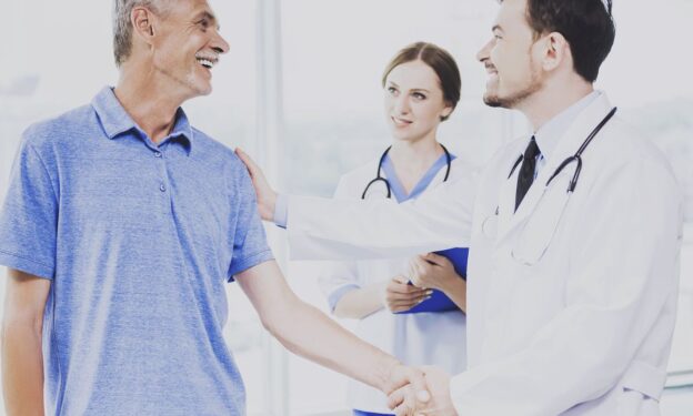 Photo of a patient and his confident doctor shaking hands. Concept of addiction being treated as a medical condition.